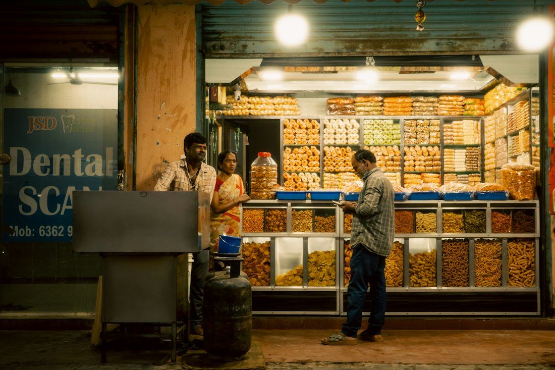 A brightly lit sweet and snack stall at night