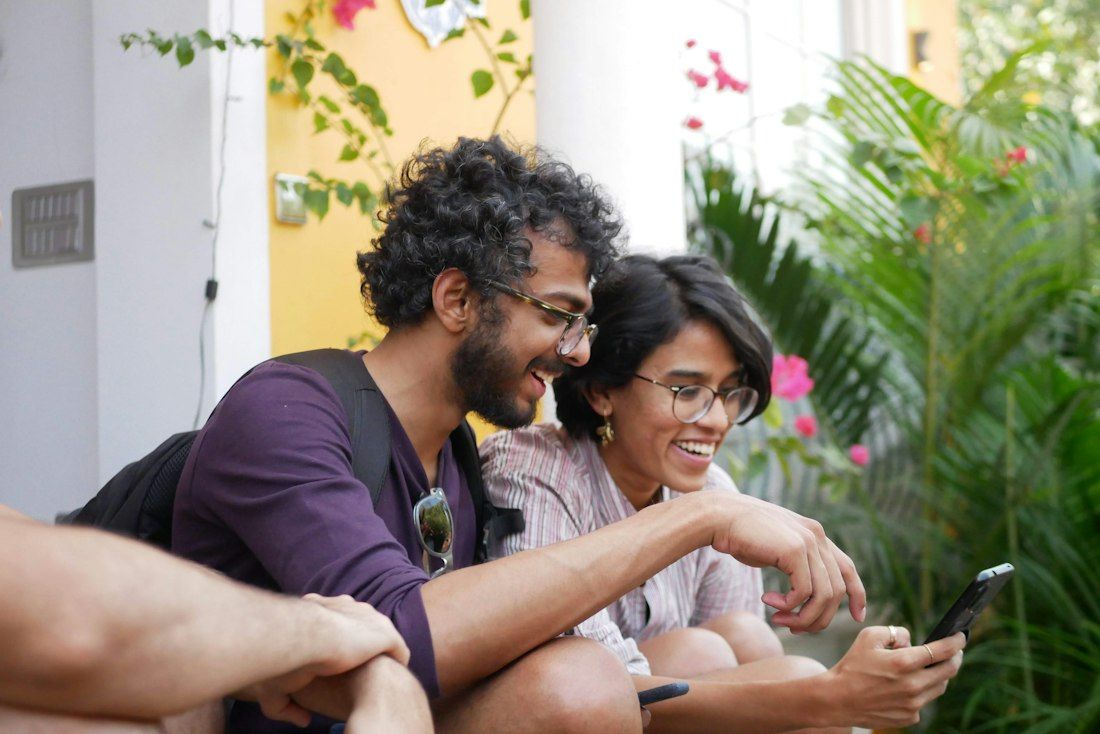 Young friends laughing together over a phone
