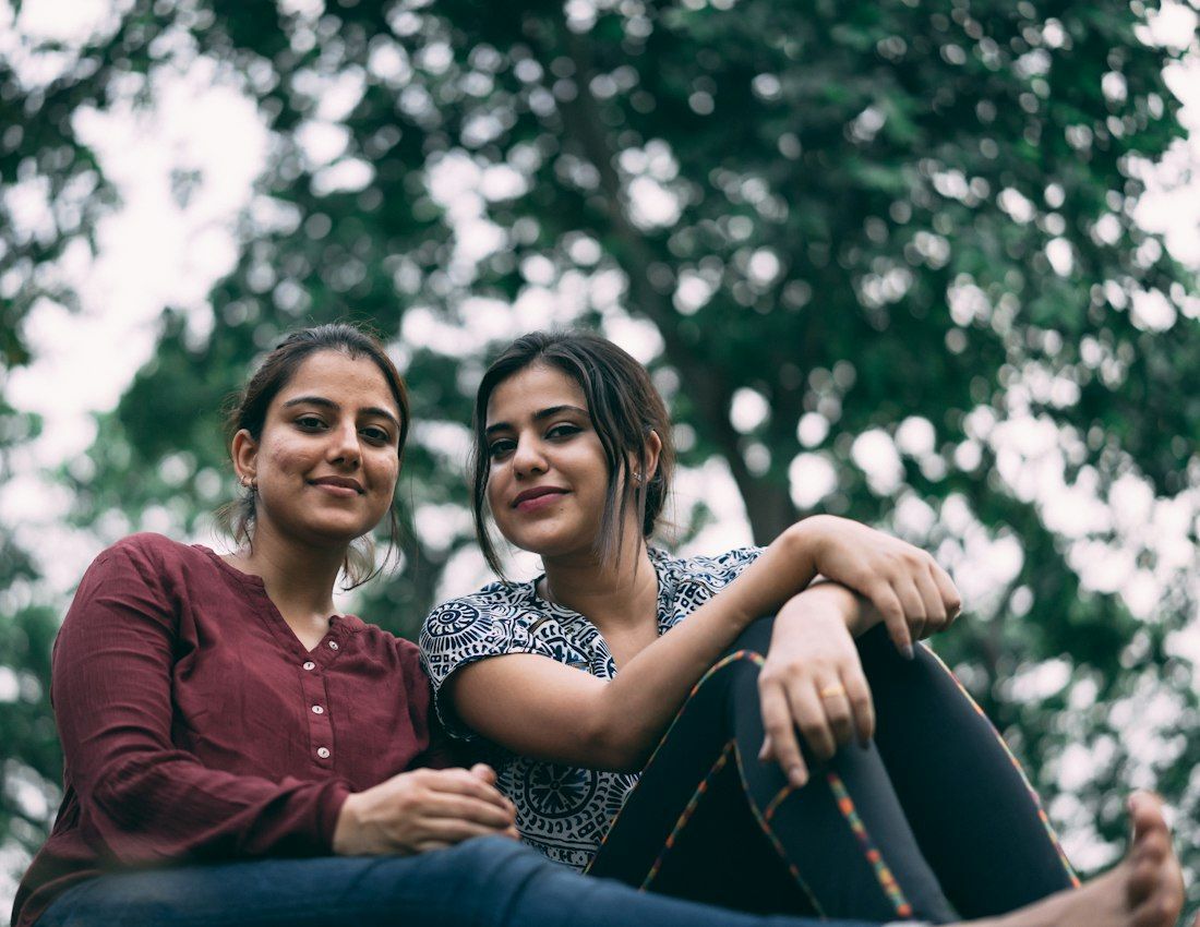 Two young women friends smiling together outdoors