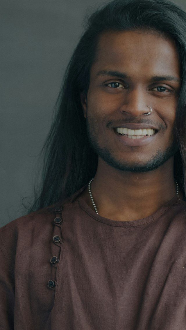 Portrait of a smiling young man with long hair