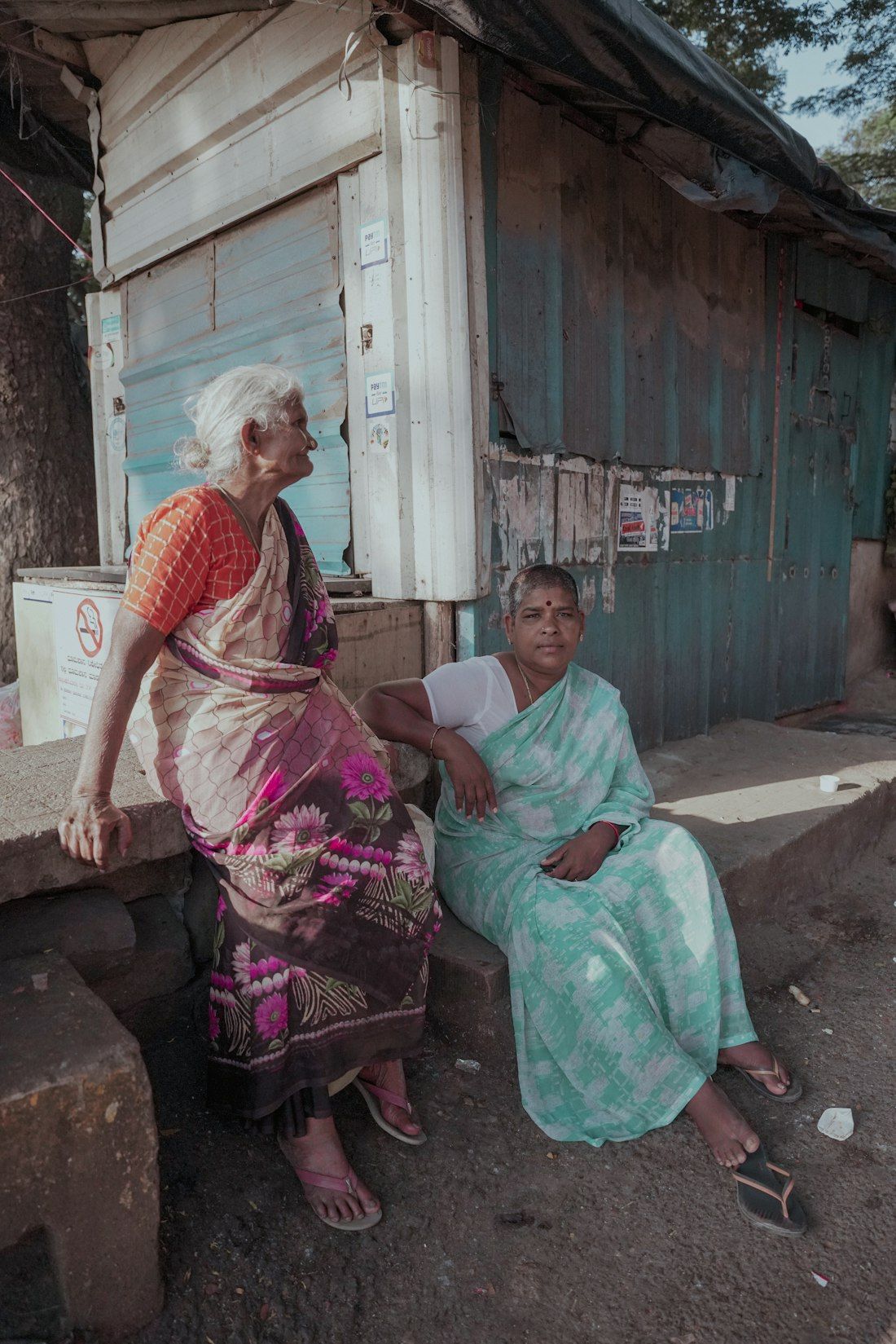 Two elderly women chatting outside a neighbourhood shop