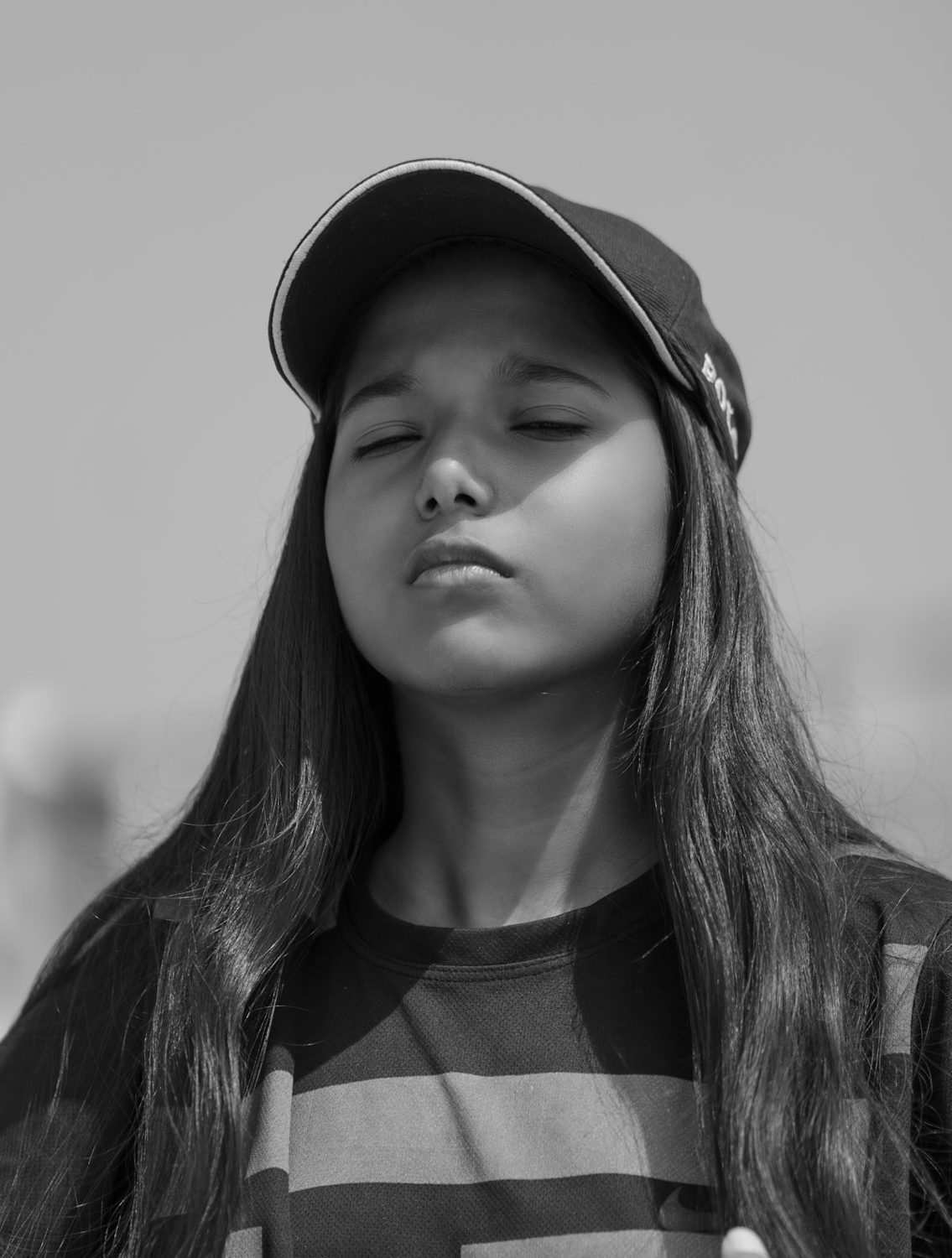 Young woman in a cap with her eyes closed, in black and white