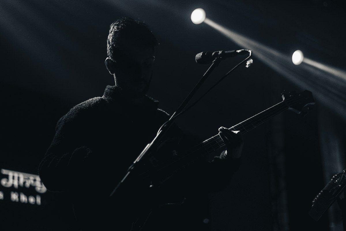 Silhouette of a guitarist on stage under spotlights