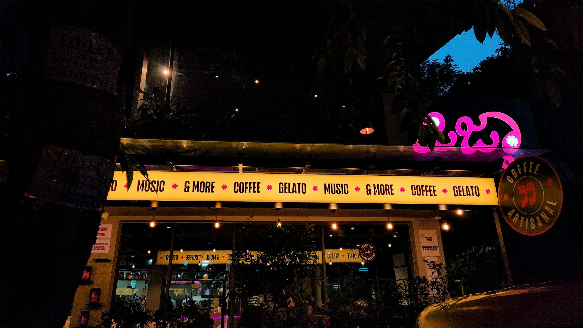 Café frontage lit with marquee lights at night
