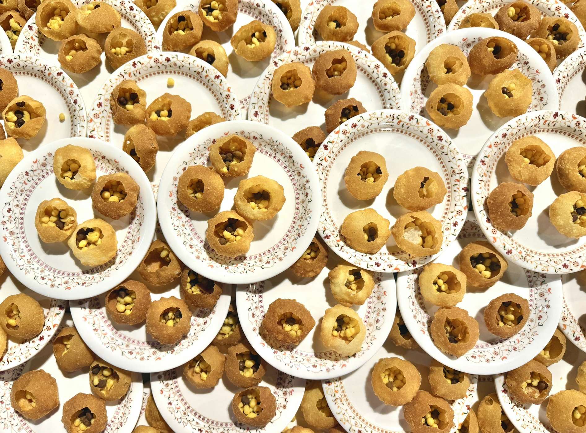 Overhead view of many plates of pani puri