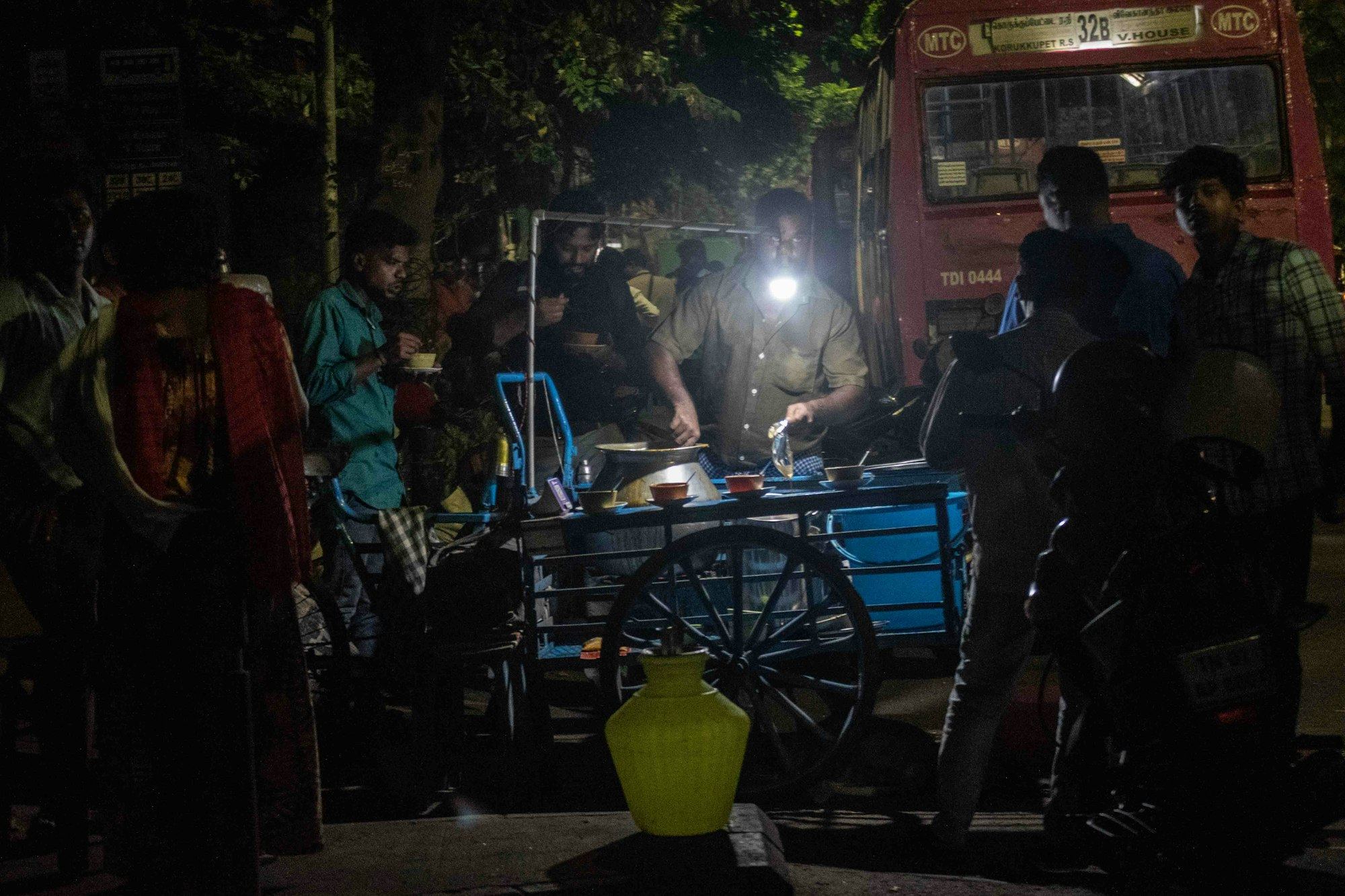 A busy street-food cart at night