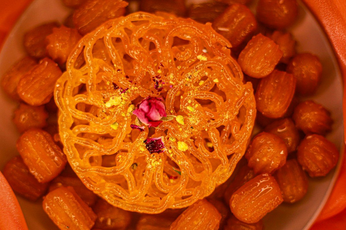 Golden jalebi and round sweets on a plate