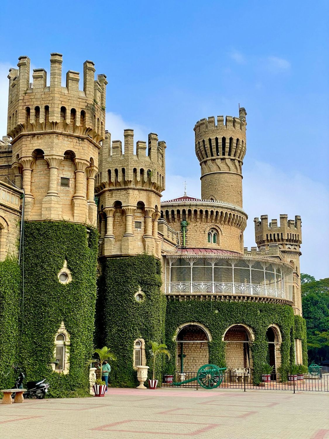 Bangalore Palace towers covered in ivy under a blue sky