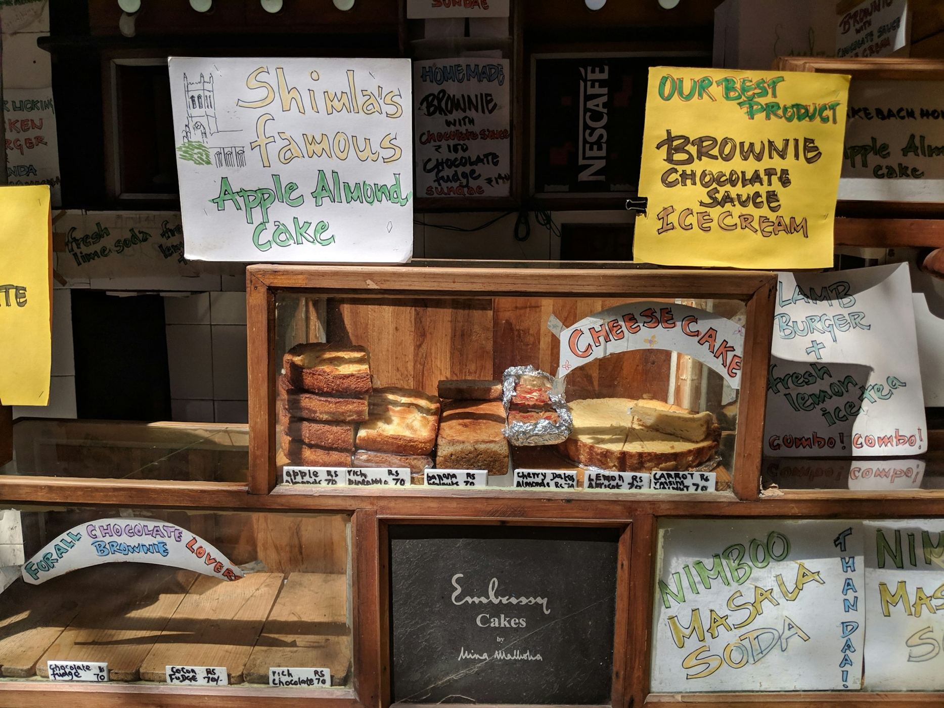 Bakery counter with handwritten signs for brownies and cakes