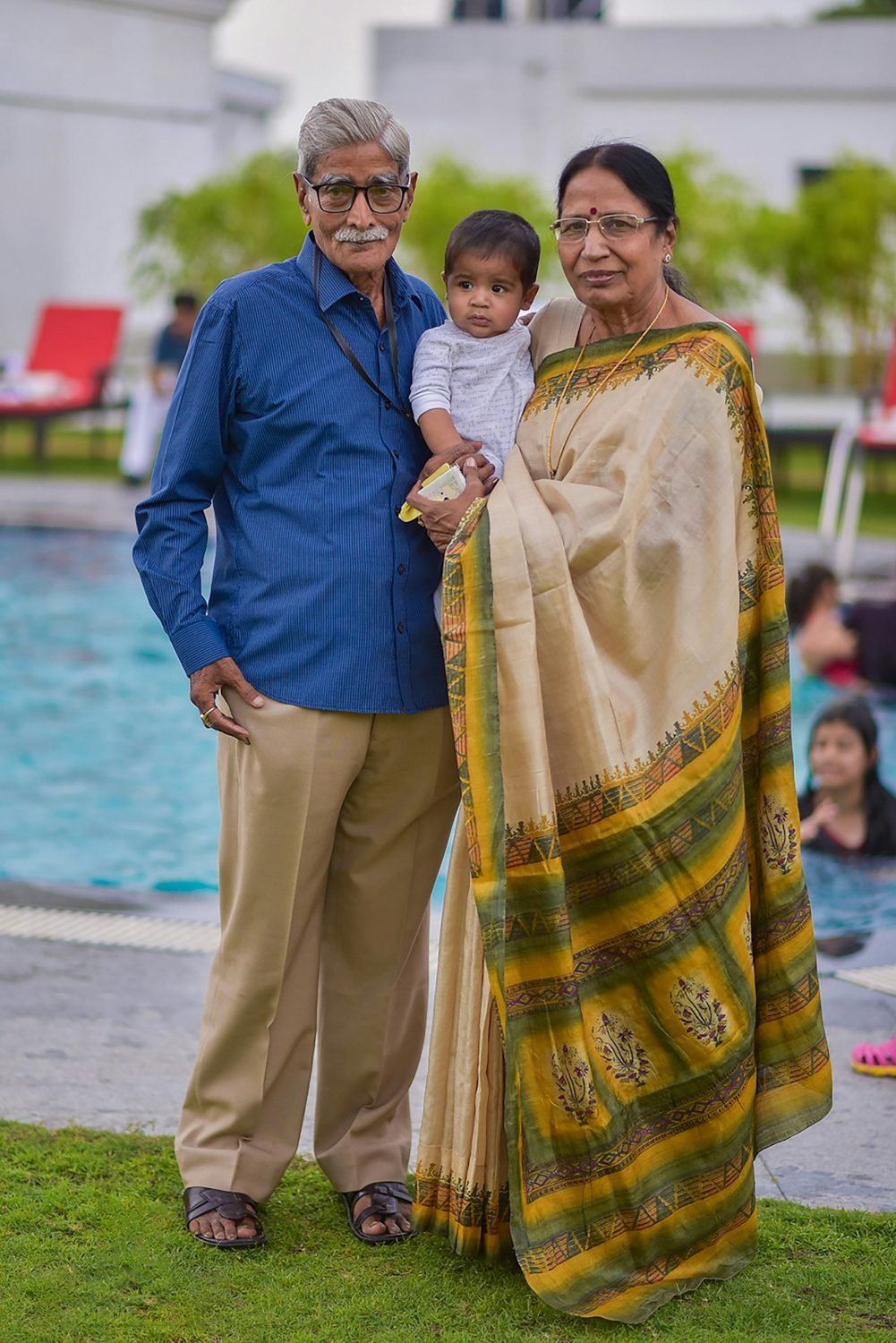 Elderly couple holding their grandchild outdoors