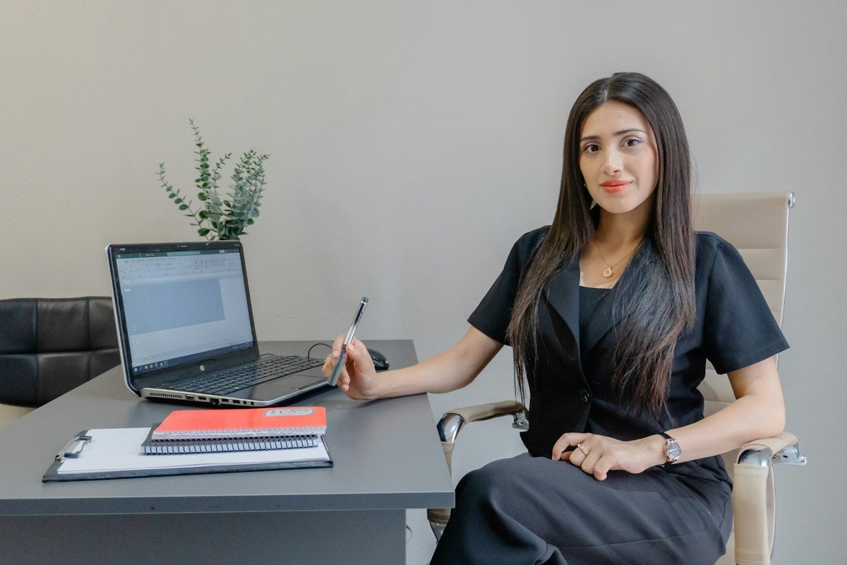 A woman working at a desk with a laptop