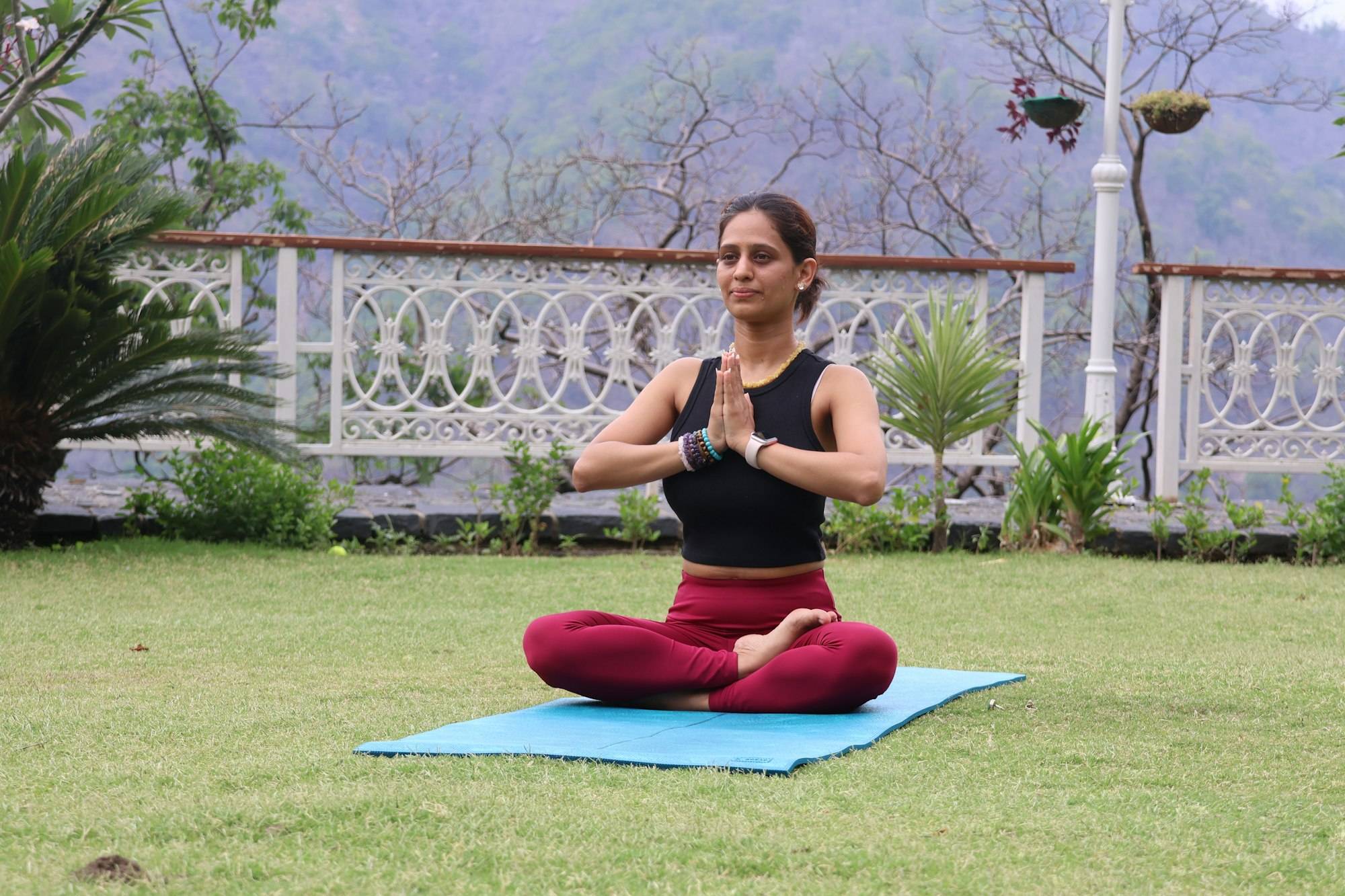 Woman meditating on a yoga mat in a garden